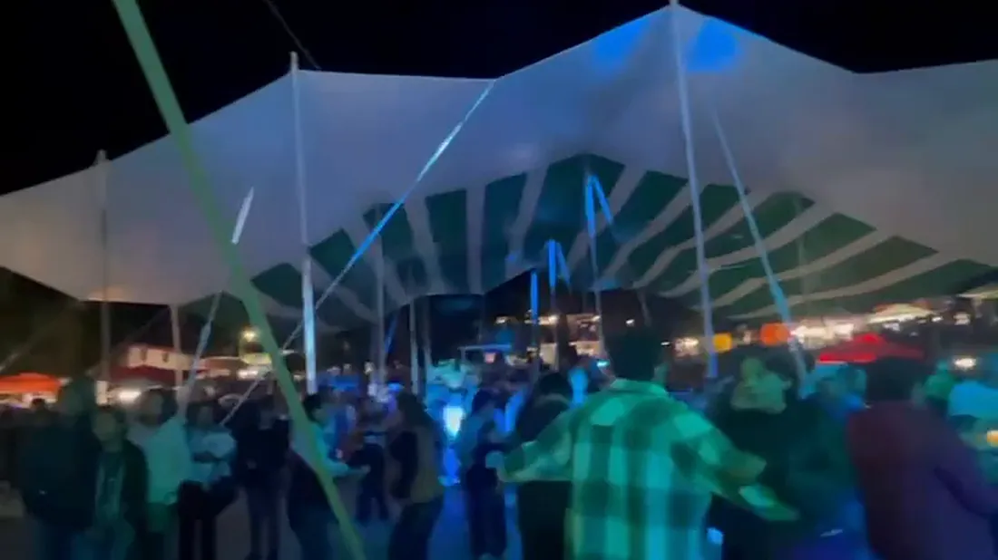 La gente bailando bajo la carpa de la feria