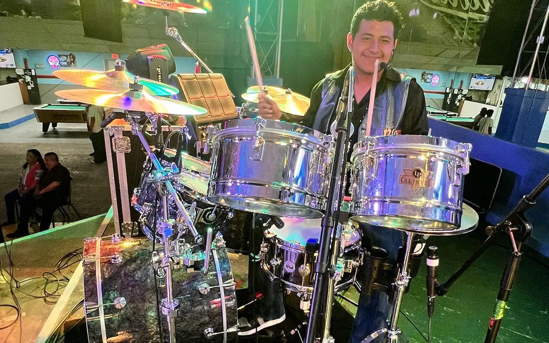 La batería bajo las luces verdes del escenario